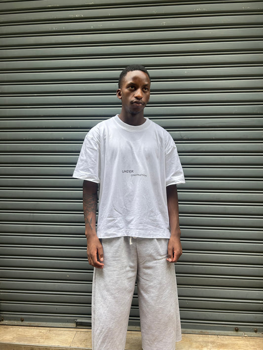 Person wearing a white outfit standing against a metallic background